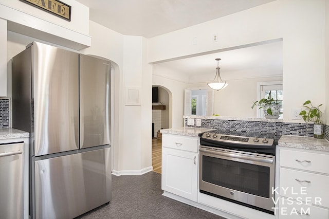 1058 Eastwood Ave SE, East Grand Rapids, MI 49506 - kitchen with appliances with stainless steel finishes, arched walkways, decorative backsplash, white cabinets, and a peninsula