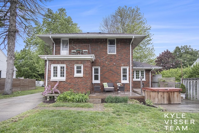 1058 Eastwood Ave SE, East Grand Rapids, MI 49506 - back of property with a hot tub, a wooden deck, brick siding, and a balcony