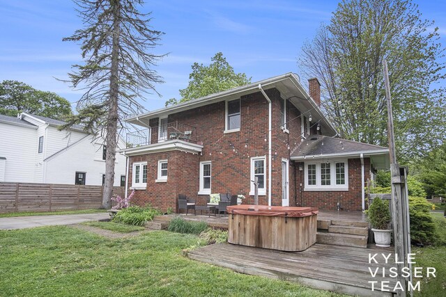 1058 Eastwood Ave SE, East Grand Rapids, MI 49506 - back of house with brick siding, a hot tub, a chimney, a deck, and a balcony
