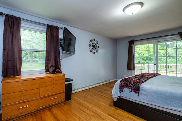 1402 Niles Buchanan Rd, Niles, MI 49120 - bedroom featuring baseboard heating, light wood-type flooring, multiple windows, and access to outside