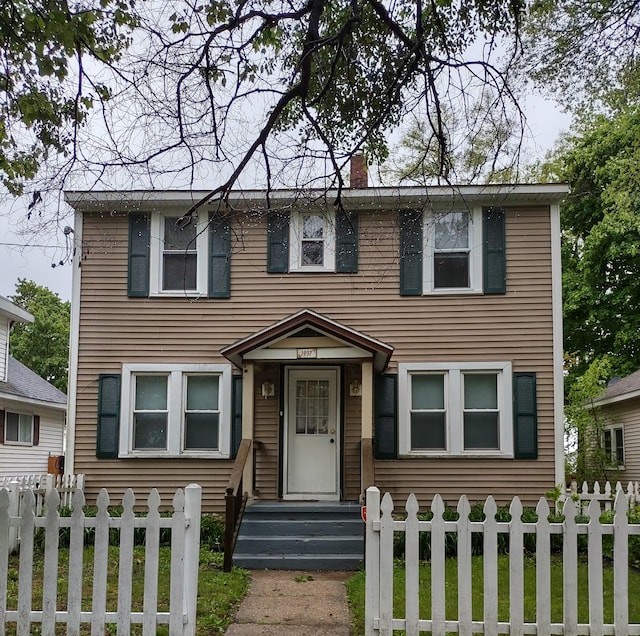 1837 Franklin St, Muskegon, MI 49441 - view of front of house featuring a chimney and a fenced front yard