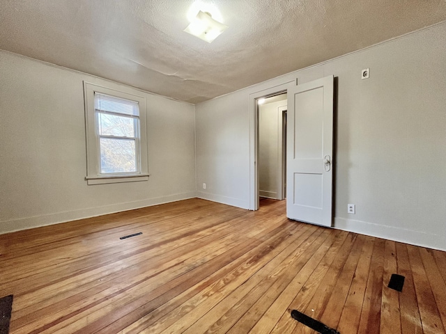 1837 Franklin St, Muskegon, MI 49441 - spare room featuring light wood-style floors, baseboards, and a textured ceiling