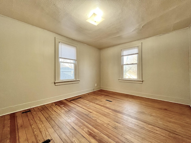 1837 Franklin St, Muskegon, MI 49441 - spare room featuring light wood-style flooring, a textured ceiling, and baseboards