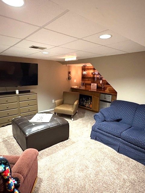 1376 Leisure Dr, Flint, MI 48507 - living room with carpet, a paneled ceiling, and bar area