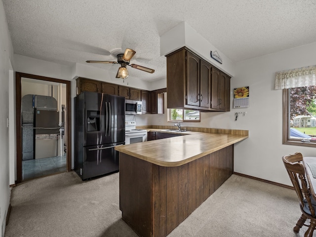 29415 Private Dr, Chesterfield, MI 48047 - kitchen with black fridge with ice dispenser, white range with electric cooktop, light carpet, a peninsula, and stainless steel microwave