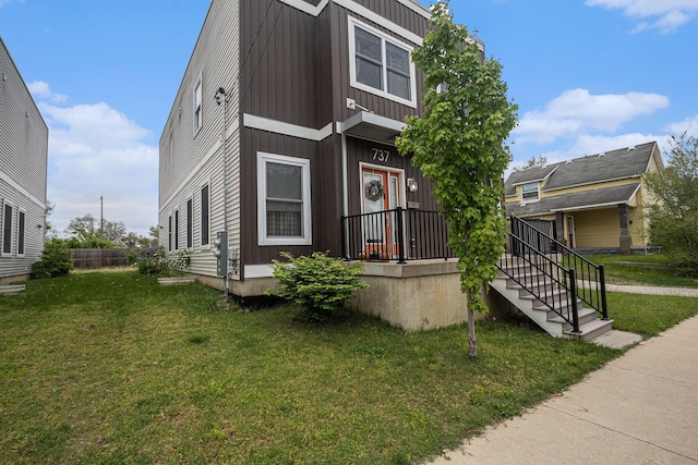 737 Bates St SE, Grand Rapids, MI 49503 - view of front facade with a front yard and board and batten siding