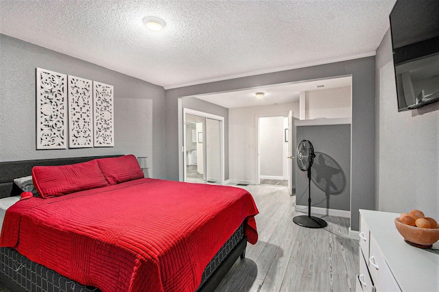 1912 E Centre Ave, Portage, MI 49002 - bedroom featuring light wood-style flooring, a textured ceiling, baseboards, and a closet