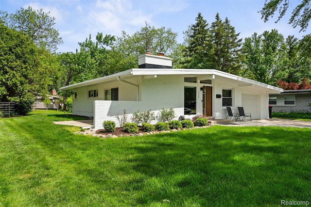 29748 Chelmsford Rd, Southfield, MI 48076 - rear view of property featuring a chimney, an attached garage, a yard, and brick siding