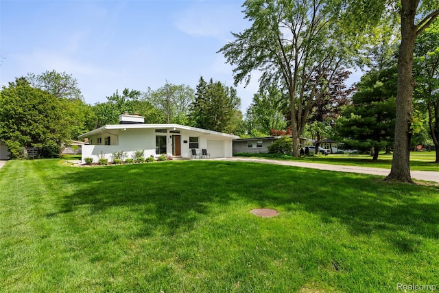 29748 Chelmsford Rd, Southfield, MI 48076 - mid-century inspired home with a garage, concrete driveway, a front lawn, and stucco siding