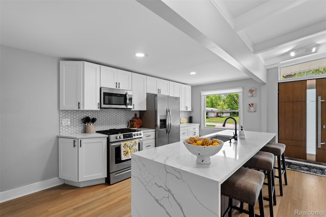29748 Chelmsford Rd, Southfield, MI 48076 - kitchen with stainless steel appliances, light wood finished floors, a kitchen bar, tasteful backsplash, and recessed lighting