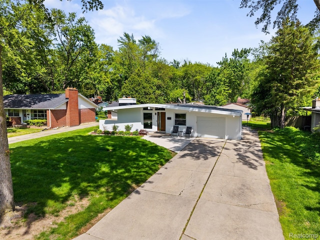29748 Chelmsford Rd, Southfield, MI 48076 - mid-century modern home with an attached garage, a front lawn, driveway, and stucco siding