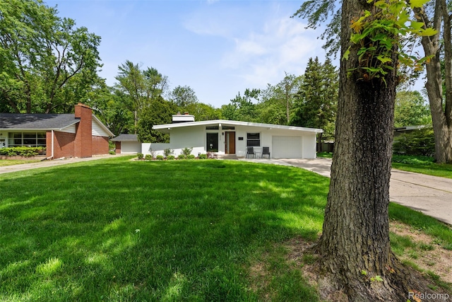 29748 Chelmsford Rd, Southfield, MI 48076 - mid-century modern home featuring an attached garage, concrete driveway, and a front yard