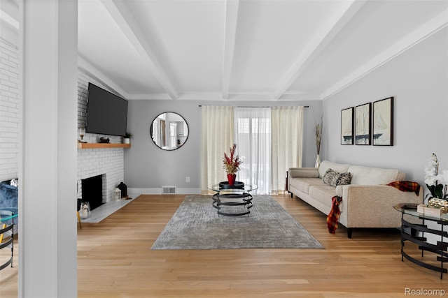 29748 Chelmsford Rd, Southfield, MI 48076 - living room with beamed ceiling, a brick fireplace, light wood-type flooring, and baseboards