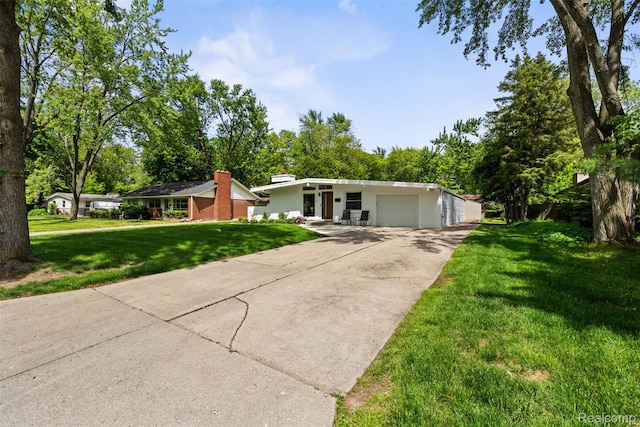29748 Chelmsford Rd, Southfield, MI 48076 - mid-century inspired home with a front lawn, concrete driveway, an attached garage, and view of scattered trees
