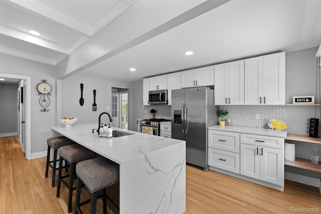 29748 Chelmsford Rd, Southfield, MI 48076 - kitchen featuring stainless steel appliances, a sink, light stone counters, backsplash, and light wood-style floors