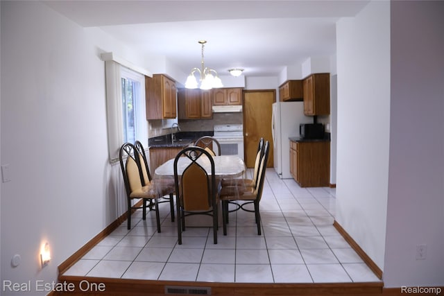 18675 Webster Ave, Southfield, MI 48076 - dining space featuring a chandelier, light tile patterned flooring, and baseboards