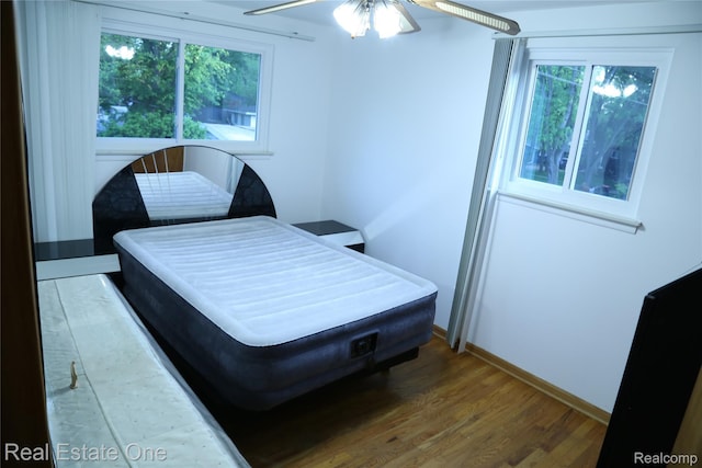 18675 Webster Ave, Southfield, MI 48076 - bedroom with wood finished floors, multiple windows, baseboards, and a ceiling fan