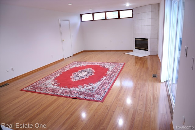 18675 Webster Ave, Southfield, MI 48076 - unfurnished living room featuring wood finished floors, a tile fireplace, baseboards, and recessed lighting