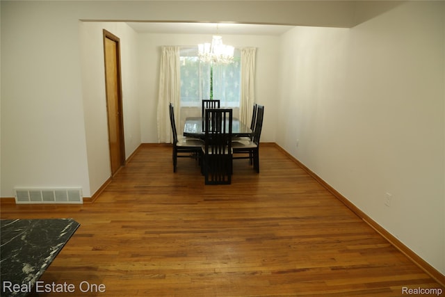 18675 Webster Ave, Southfield, MI 48076 - dining room featuring a chandelier, wood finished floors, and baseboards