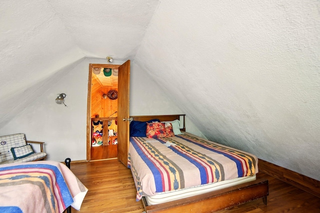 841 W Woodland Park Dr, Bitely, MI 49309 - bedroom with wood finished floors, lofted ceiling, baseboards, and a textured ceiling