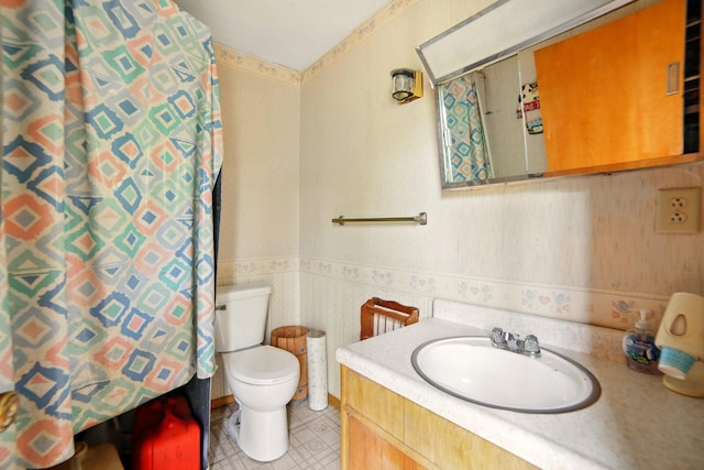841 W Woodland Park Dr, Bitely, MI 49309 - bathroom with a wainscoted wall, toilet, vanity, curtained shower, and wallpapered walls