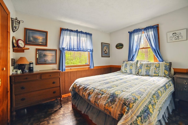 841 W Woodland Park Dr, Bitely, MI 49309 - bedroom featuring multiple windows, a wainscoted wall, and wood walls