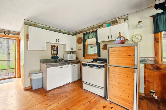 841 W Woodland Park Dr, Bitely, MI 49309 - kitchen featuring white appliances, white cabinets, plenty of natural light, and light wood-style flooring