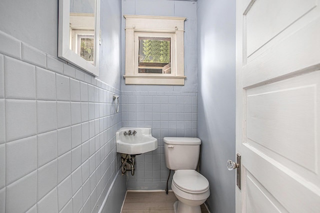176 N Union St, Battle Creek, MI 49017 - bathroom featuring toilet, tile walls, healthy amount of natural light, and wood finished floors