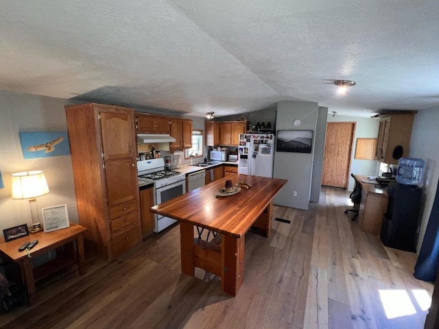 2828 Trepanier Dr Unit 515, Ludington, MI 49431 - kitchen featuring white appliances, wood-type flooring, a sink, brown cabinets, and lofted ceiling