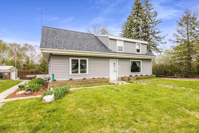 7256 Highland Dr, Beulah, MI 49617 - bungalow with a front lawn, a shingled roof, and an outbuilding