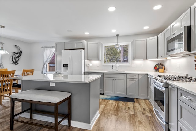 7256 Highland Dr, Beulah, MI 49617 - kitchen featuring appliances with stainless steel finishes, a sink, healthy amount of natural light, a breakfast bar area, and recessed lighting