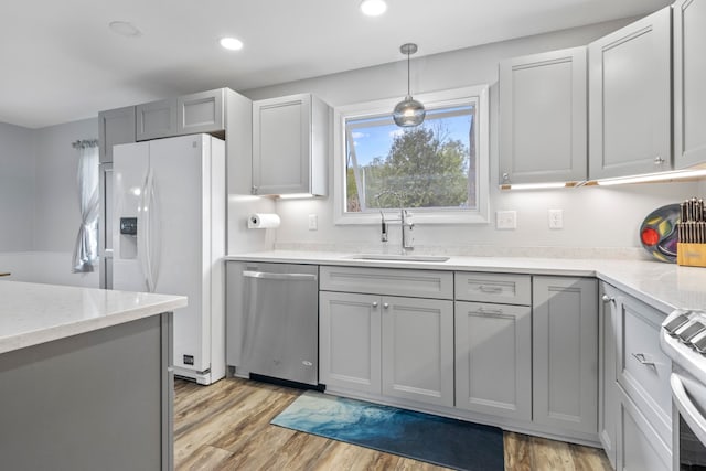 7256 Highland Dr, Beulah, MI 49617 - kitchen with stainless steel appliances, a sink, recessed lighting, light wood finished floors, and decorative light fixtures
