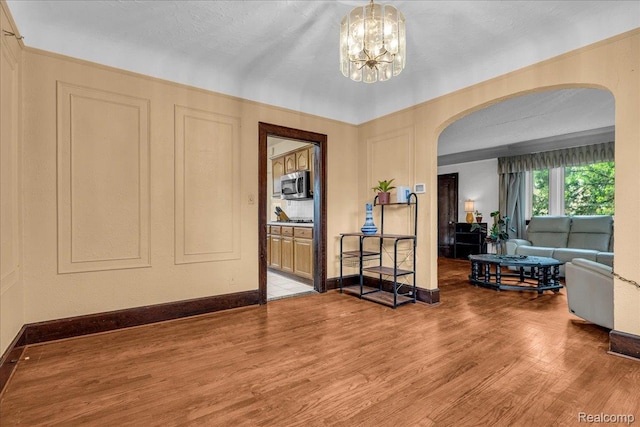 14004 Abington Ave, Detroit, MI 48227 - entrance foyer with arched walkways, wood finished floors, a chandelier, and baseboards