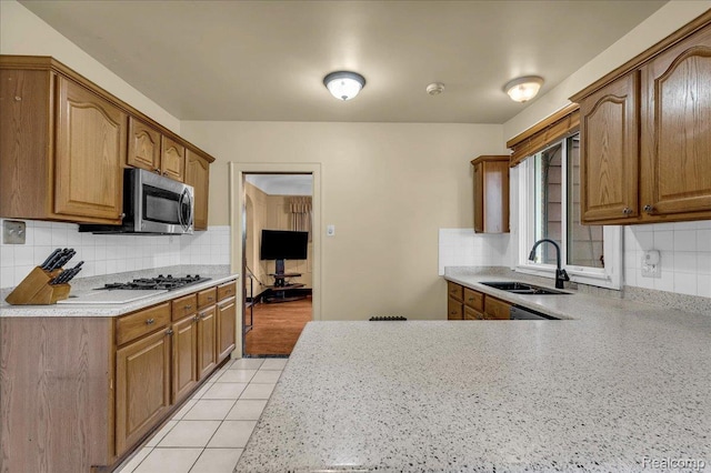 14004 Abington Ave, Detroit, MI 48227 - kitchen with a sink, tasteful backsplash, light countertops, and brown cabinetry
