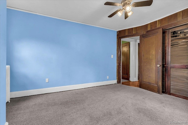 14004 Abington Ave, Detroit, MI 48227 - unfurnished bedroom with crown molding, carpet flooring, baseboards, wooden walls, and ceiling fan