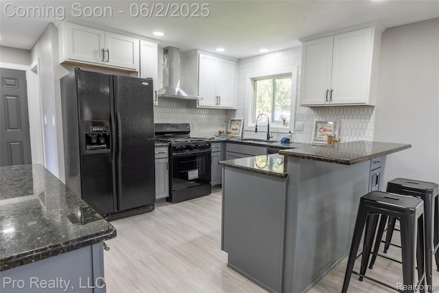 2750 Lansdowne Rd, Waterford, MI 48329 - kitchen featuring wall chimney exhaust hood, black appliances, a sink, a peninsula, and tasteful backsplash
