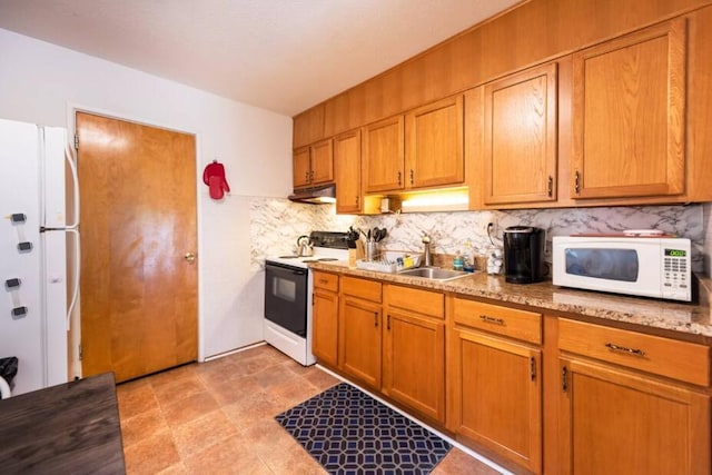 116/118 Glendale Dr, Ann Arbor, MI 48103 - kitchen featuring white appliances, a sink, under cabinet range hood, backsplash, and brown cabinetry
