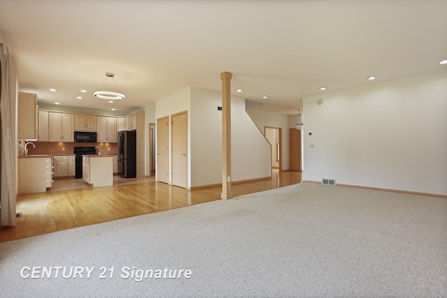 3803 Prairie Creek St, Saginaw, MI 48603 - unfurnished living room with recessed lighting, light colored carpet, baseboards, and a sink