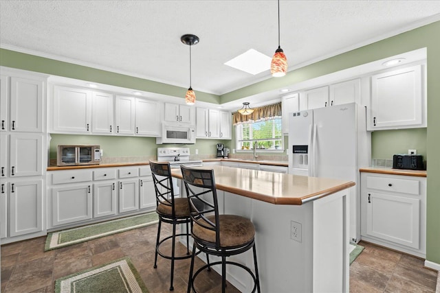 11855 Cedarbrook Dr, South Lyon, MI 48178 - kitchen with white appliances, white cabinetry, a skylight, a sink, and crown molding