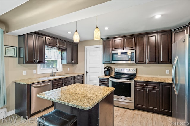 3191 Perry Ct, Grand Blanc, MI 48439 - kitchen with stainless steel appliances, a sink, dark brown cabinets, light stone countertops, and recessed lighting