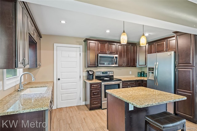3191 Perry Ct, Grand Blanc, MI 48439 - kitchen with appliances with stainless steel finishes, a sink, dark brown cabinetry, light wood-style flooring, and light stone counters