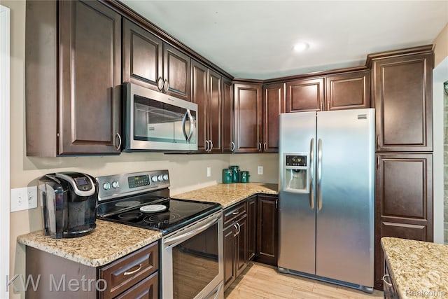3191 Perry Ct, Grand Blanc, MI 48439 - kitchen with appliances with stainless steel finishes, dark brown cabinets, and light wood-type flooring