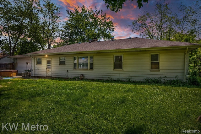 3191 Perry Ct, Grand Blanc, MI 48439 - back of property at dusk featuring a hot tub and a lawn