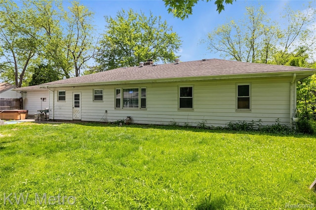 3191 Perry Ct, Grand Blanc, MI 48439 - back of house featuring a hot tub, a lawn, and a chimney