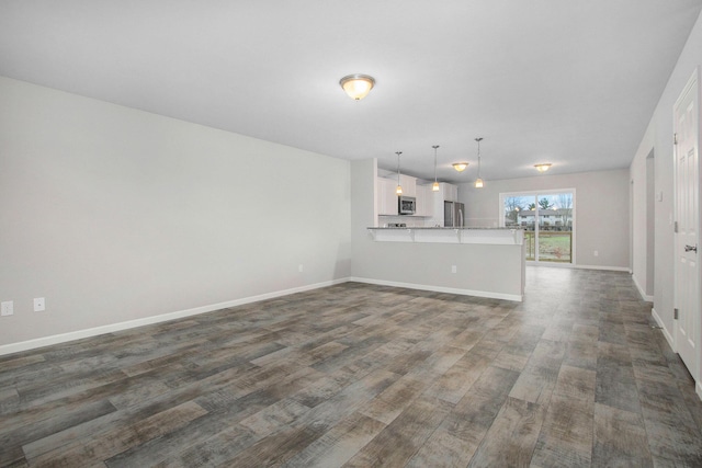 13670 Oasis Ave, Holland, MI 49424 - unfurnished living room featuring dark wood finished floors and baseboards