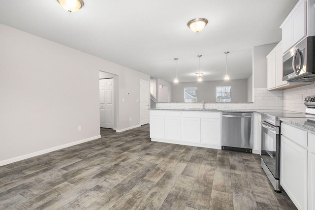 13670 Oasis Ave, Holland, MI 49424 - kitchen featuring stainless steel appliances, a peninsula, decorative backsplash, and dark wood-style flooring