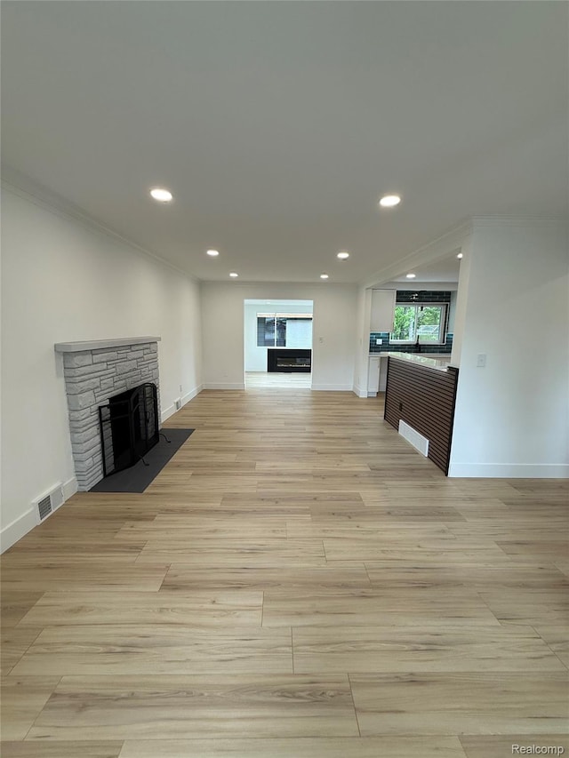 20218 Chalon St, Saint Clair Shores, MI 48080 - unfurnished living room with a stone fireplace, light wood finished floors, recessed lighting, crown molding, and baseboards