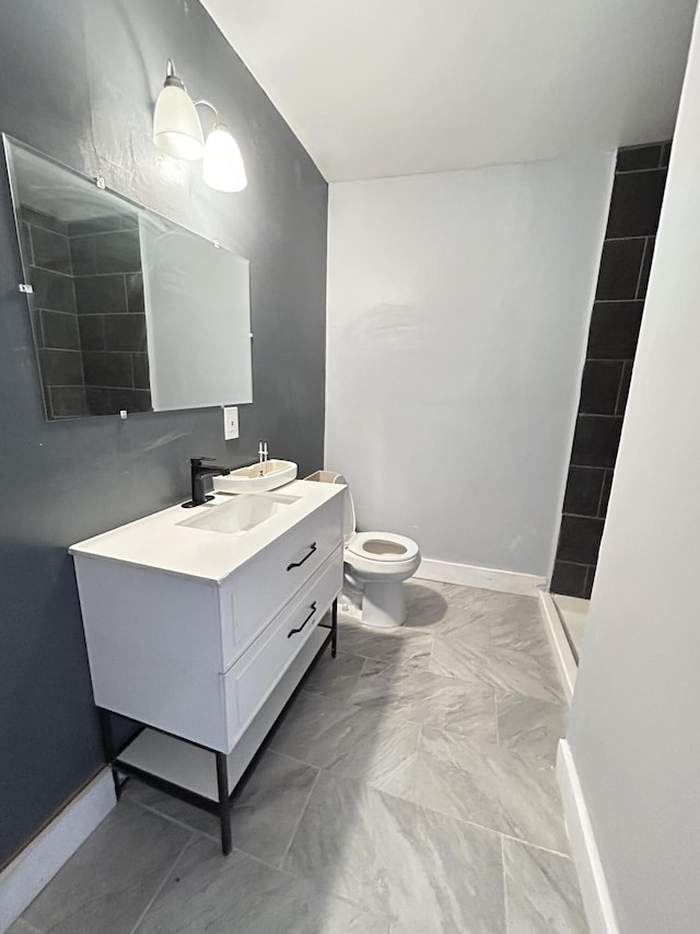 388 Chalmers St, Detroit, MI 48215 - bathroom featuring toilet, vanity, baseboards, and marble look tile flooring