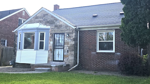 15465 Murray Hl, Detroit, MI 48227 - view of front of house featuring a chimney, stone siding, brick siding, and roof with shingles