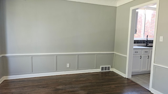 15465 Murray Hl, Detroit, MI 48227 - unfurnished room with a sink, dark wood finished floors, a decorative wall, and wainscoting